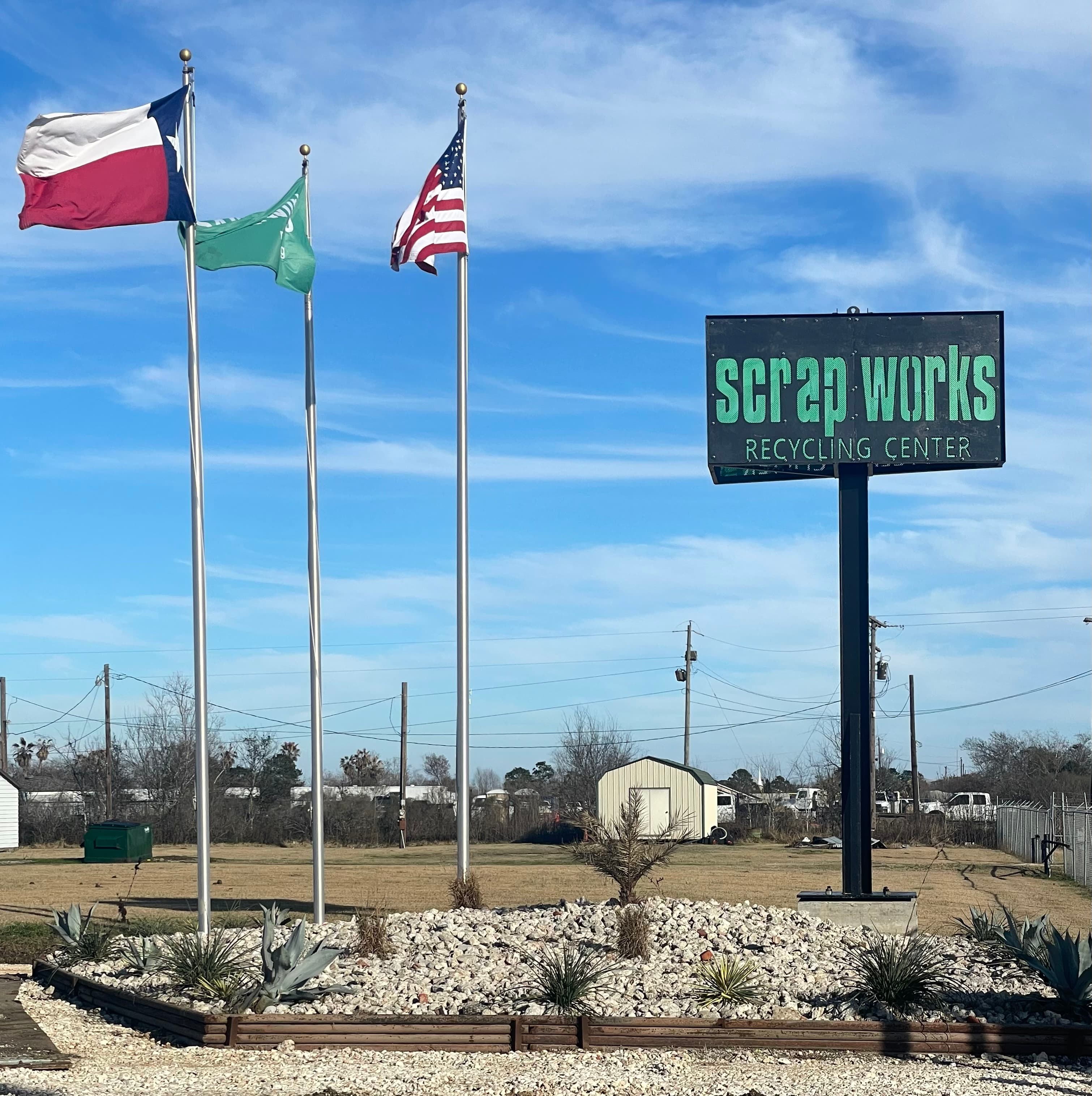Scrapworks pole sign with flags at the facility entrance